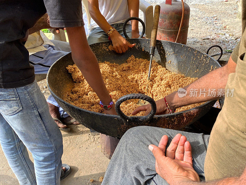 传统印度甜品Chaulai Ke Laddoo的食谱，苋菜谷物(Chaulai)，水，酥油和jaggery sugar是由不认识的印度人在一个大锅上的炉子上制作的，街头小吃